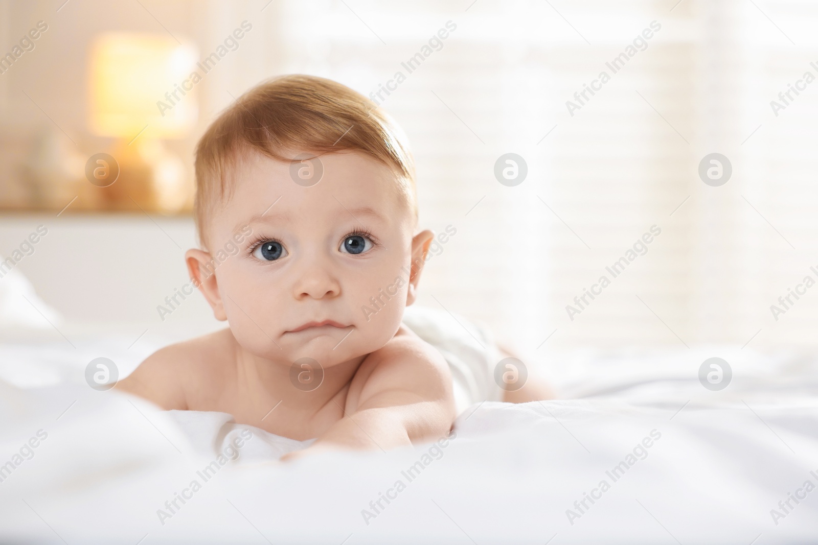 Photo of Cute baby lying on bed at home