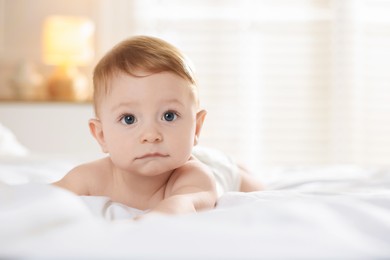 Photo of Cute baby lying on bed at home