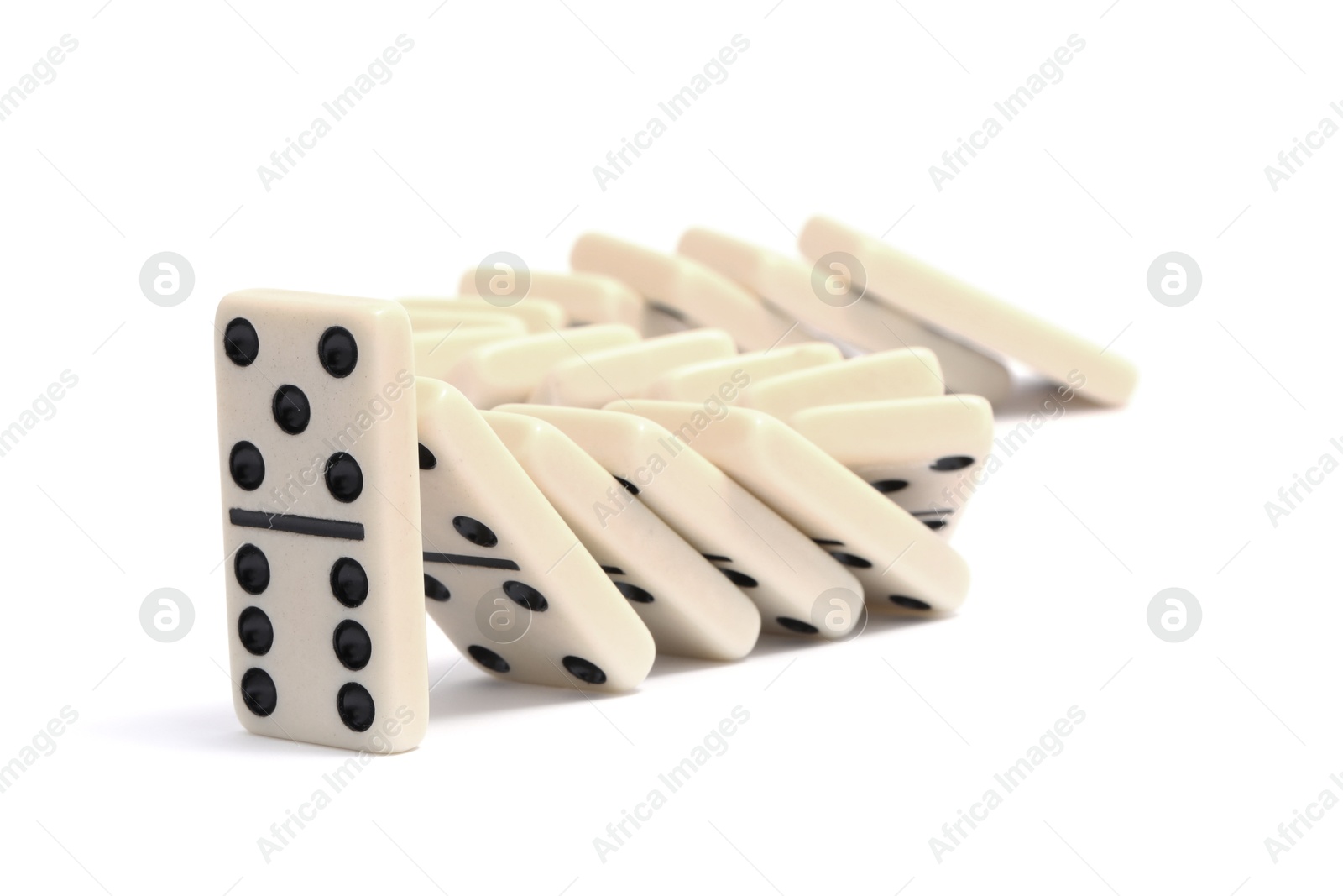 Photo of Domino effect. Tiles falling on white background