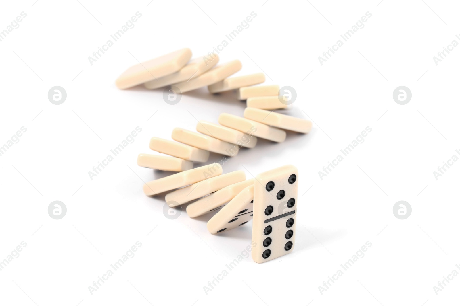 Photo of Domino effect. Tiles falling on white background