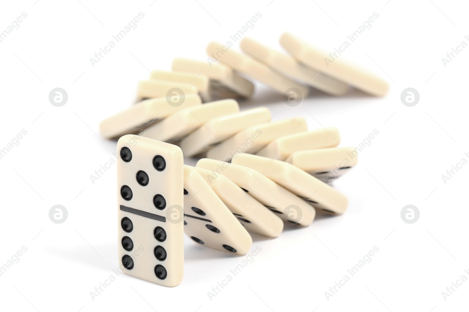 Photo of Domino effect. Tiles falling on white background