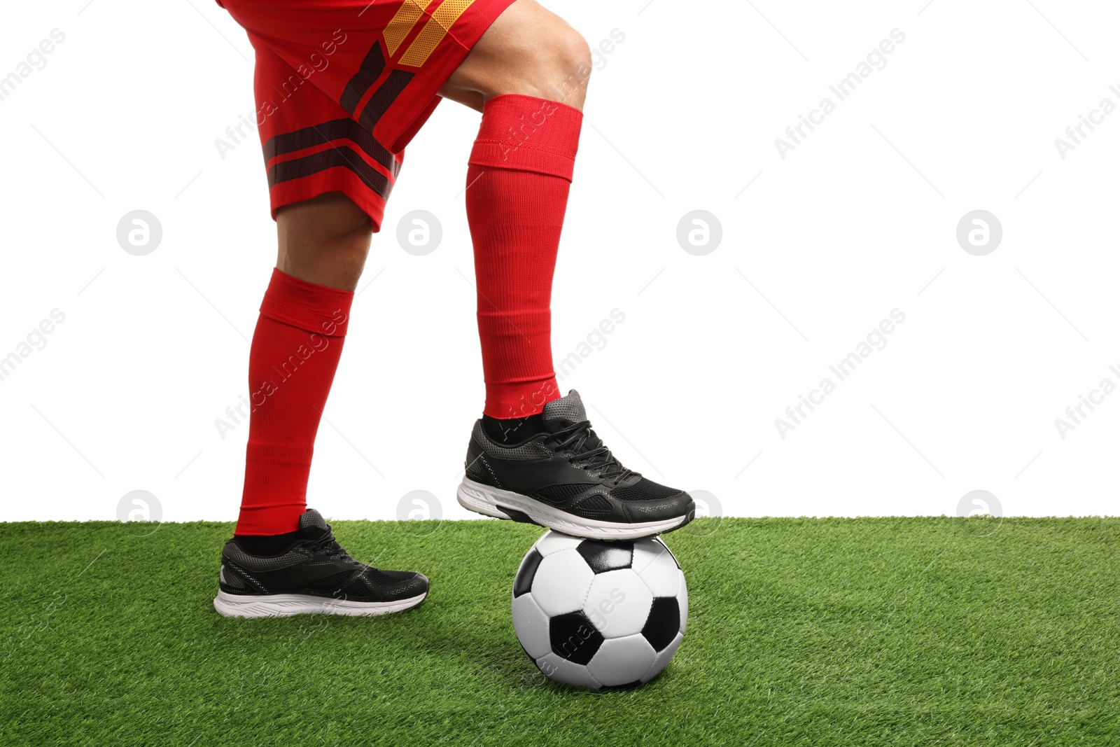 Photo of Football player with soccer ball on artificial grass against white background, closeup