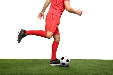 Photo of Man playing football with soccer ball on artificial grass against white background, closeup