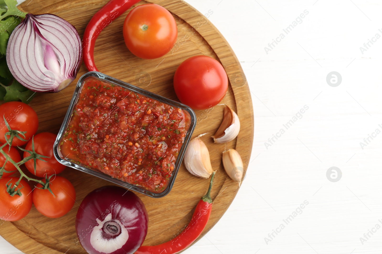 Photo of Delicious salsa sauce and ingredients on white wooden table, top view. Space for text