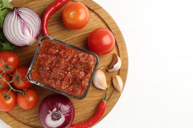 Photo of Delicious salsa sauce and ingredients on white wooden table, top view. Space for text