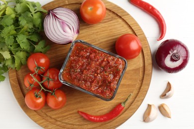 Photo of Delicious salsa sauce and ingredients on white wooden table, flat lay