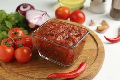 Photo of Delicious salsa sauce and ingredients on white table, closeup