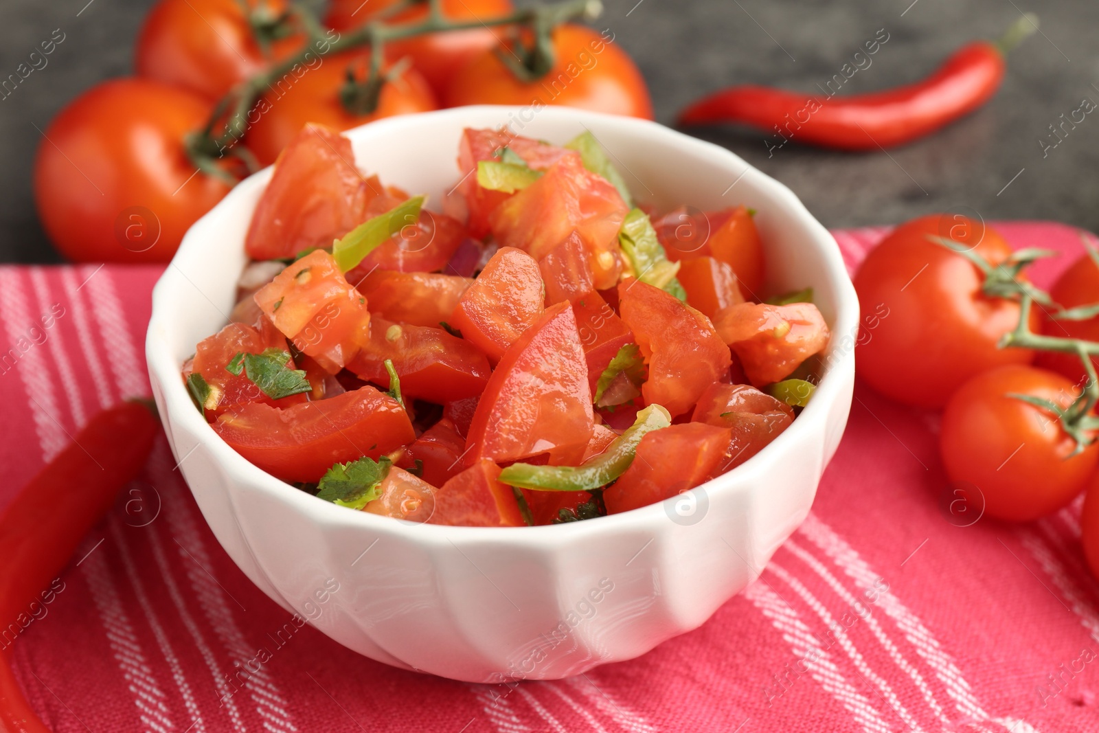 Photo of Delicious salsa (Pico de gallo) in bowl on grey table, closeup