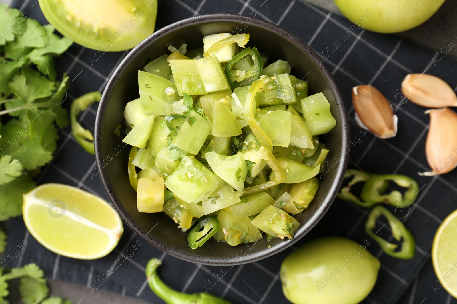 Photo of Delicious salsa (Pico de gallo) in bowl and products on table, flat lay