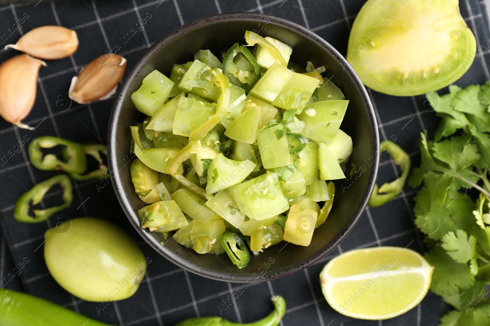 Photo of Delicious salsa (Pico de gallo) in bowl and products on table, flat lay