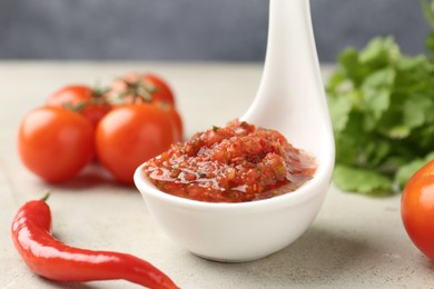 Photo of Delicious salsa sauce and ingredients on light textured table, closeup