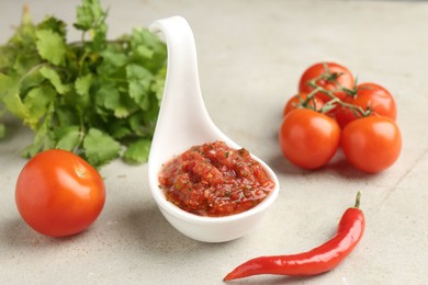 Photo of Delicious salsa sauce and ingredients on light textured table, closeup