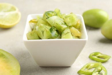 Photo of Delicious salsa (Pico de gallo) in bowl and products on light textured table, closeup