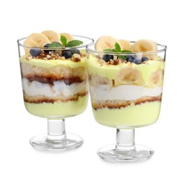 Photo of Tasty trifle dessert. Banana, blueberries, sponge cake and whipped cream in glasses isolated on white