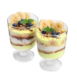 Photo of Tasty trifle dessert. Banana, blueberries, sponge cake and whipped cream in glasses isolated on white