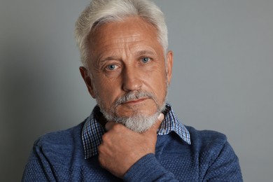 Photo of Portrait of senior man on grey background