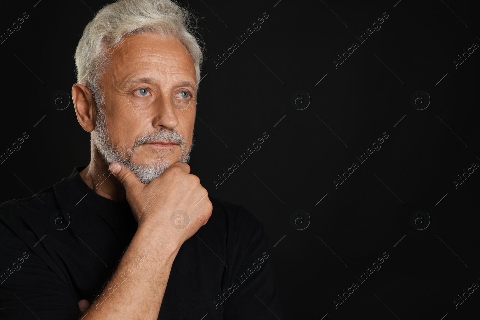 Photo of Portrait of senior man on black background, space for text