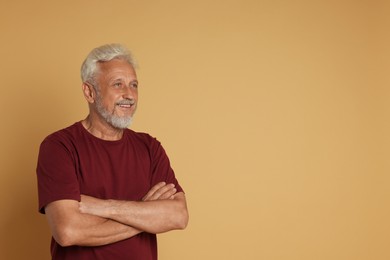 Portrait of senior man on beige background, space for text