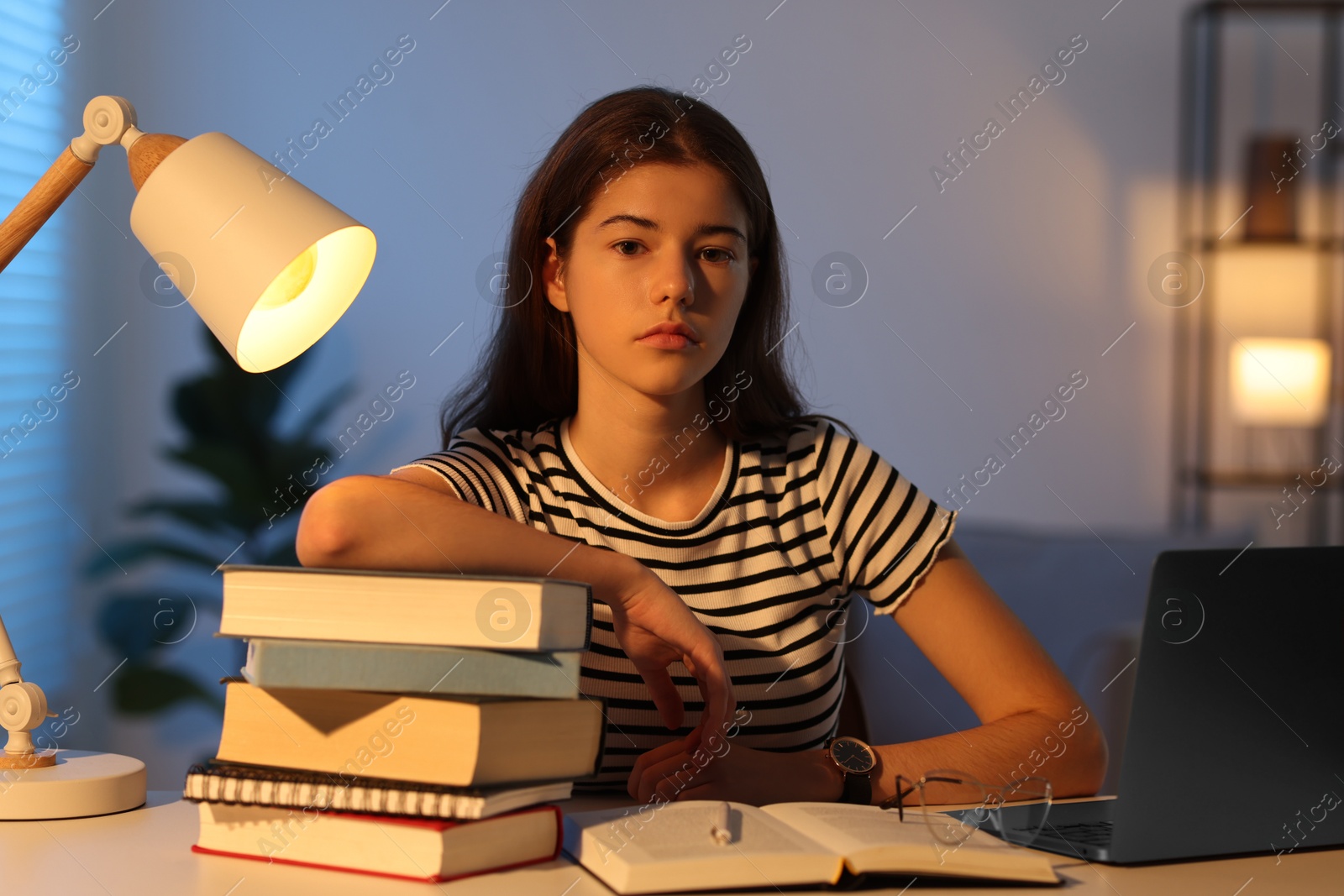 Photo of Preparing for exam. Student with books at table indoors