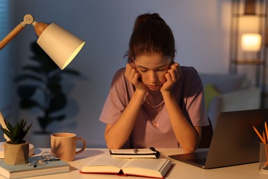 Photo of Preparing for exam. Tired student sleeping at table indoors