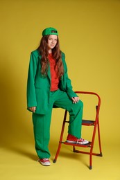 Photo of Fashion portrait of red-haired teenage girl on golden background