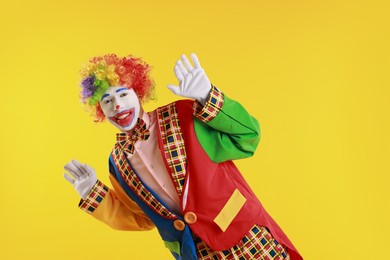 Photo of Portrait of emotional clown on yellow background