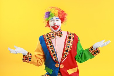 Photo of Portrait of emotional clown on yellow background