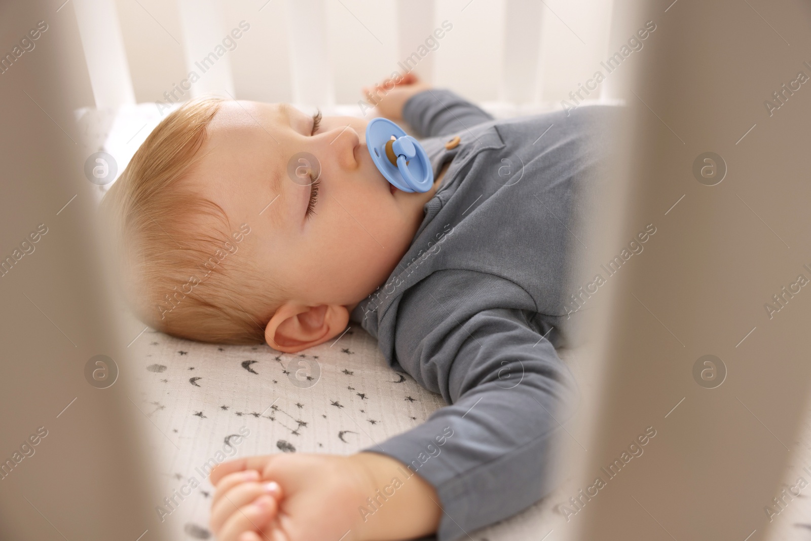 Photo of Cute baby sleeping in crib at home, closeup