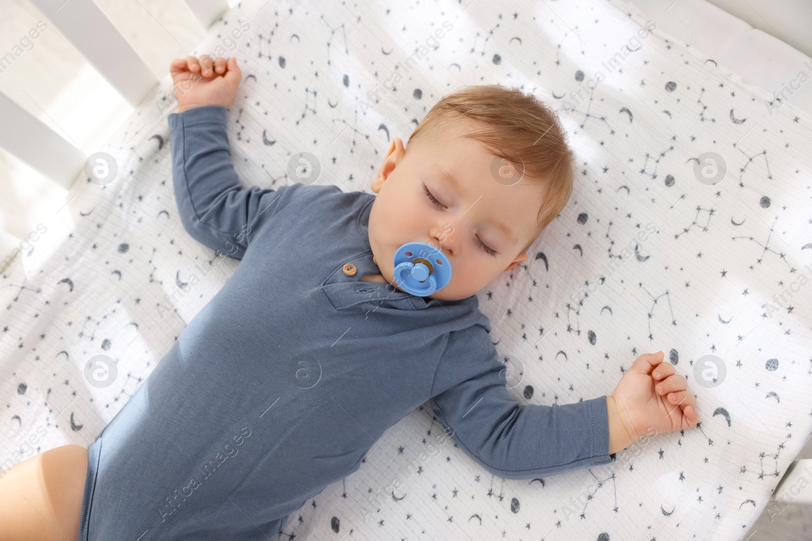 Photo of Cute baby sleeping in crib at home, top view