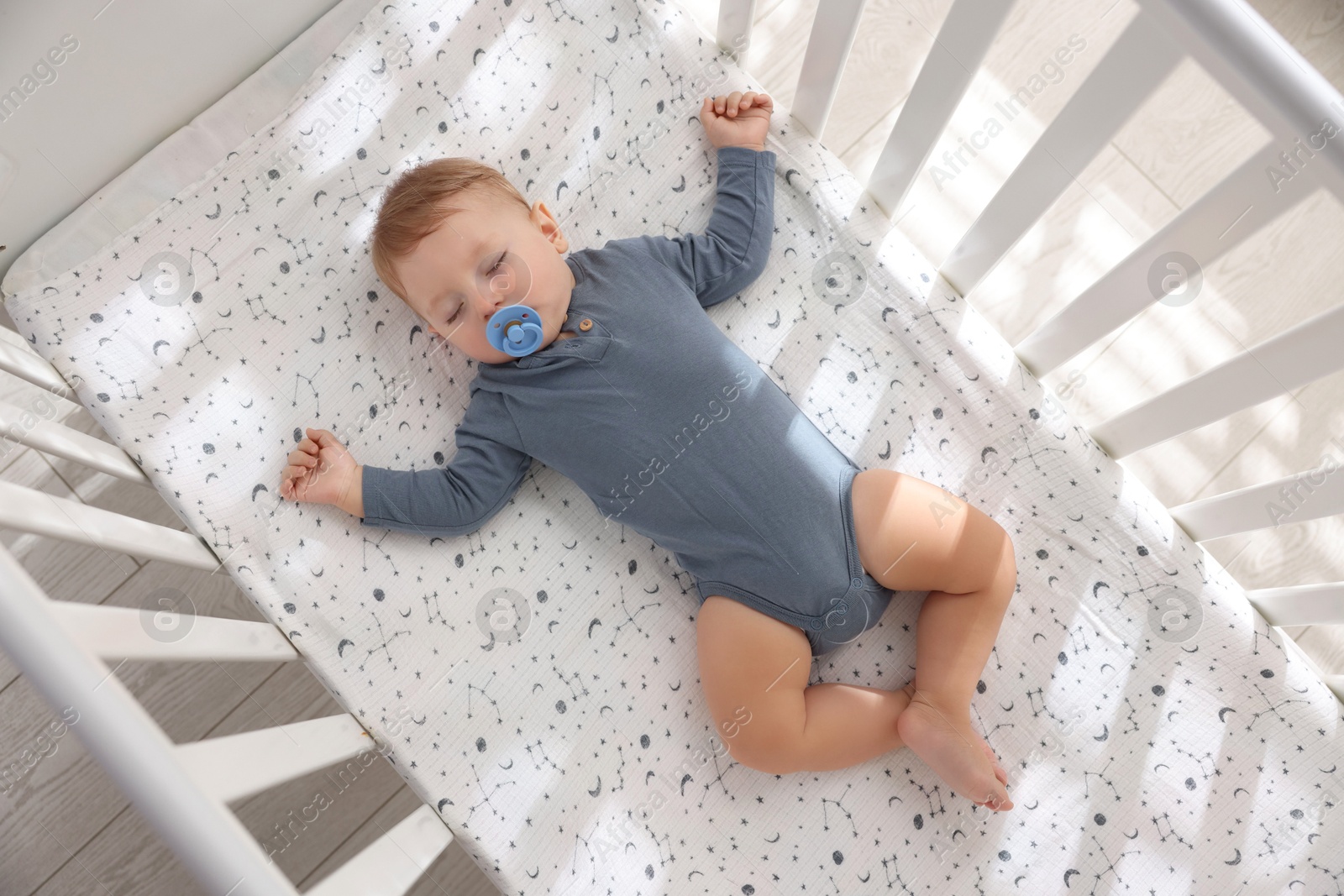 Photo of Cute baby sleeping in crib at home, top view