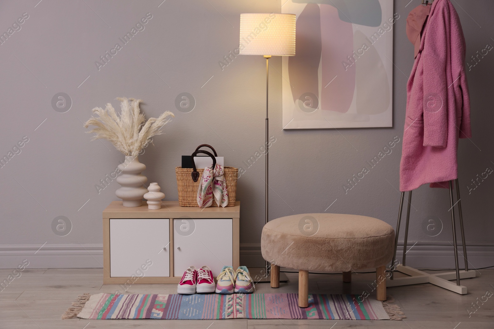 Photo of Stylish hallway interior with pouf and lamp