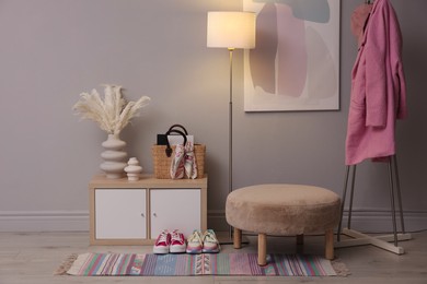 Photo of Stylish hallway interior with pouf and lamp