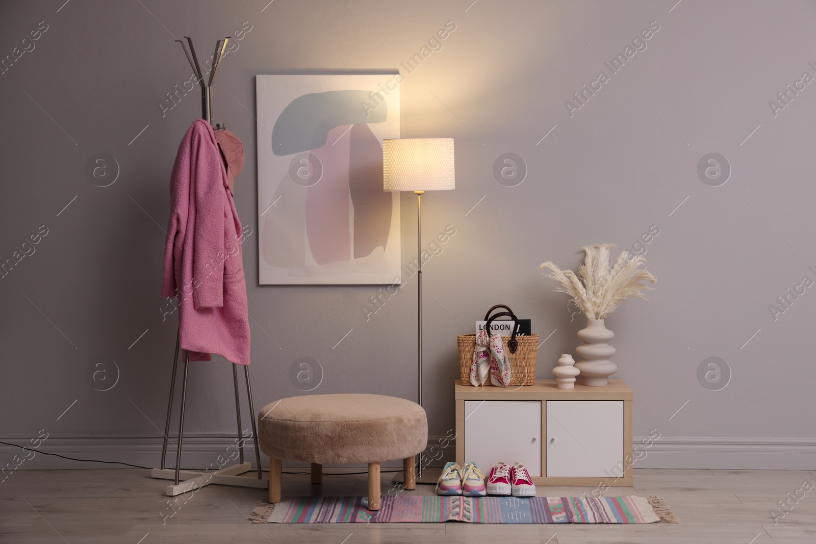 Photo of Stylish hallway interior with pouf and lamp