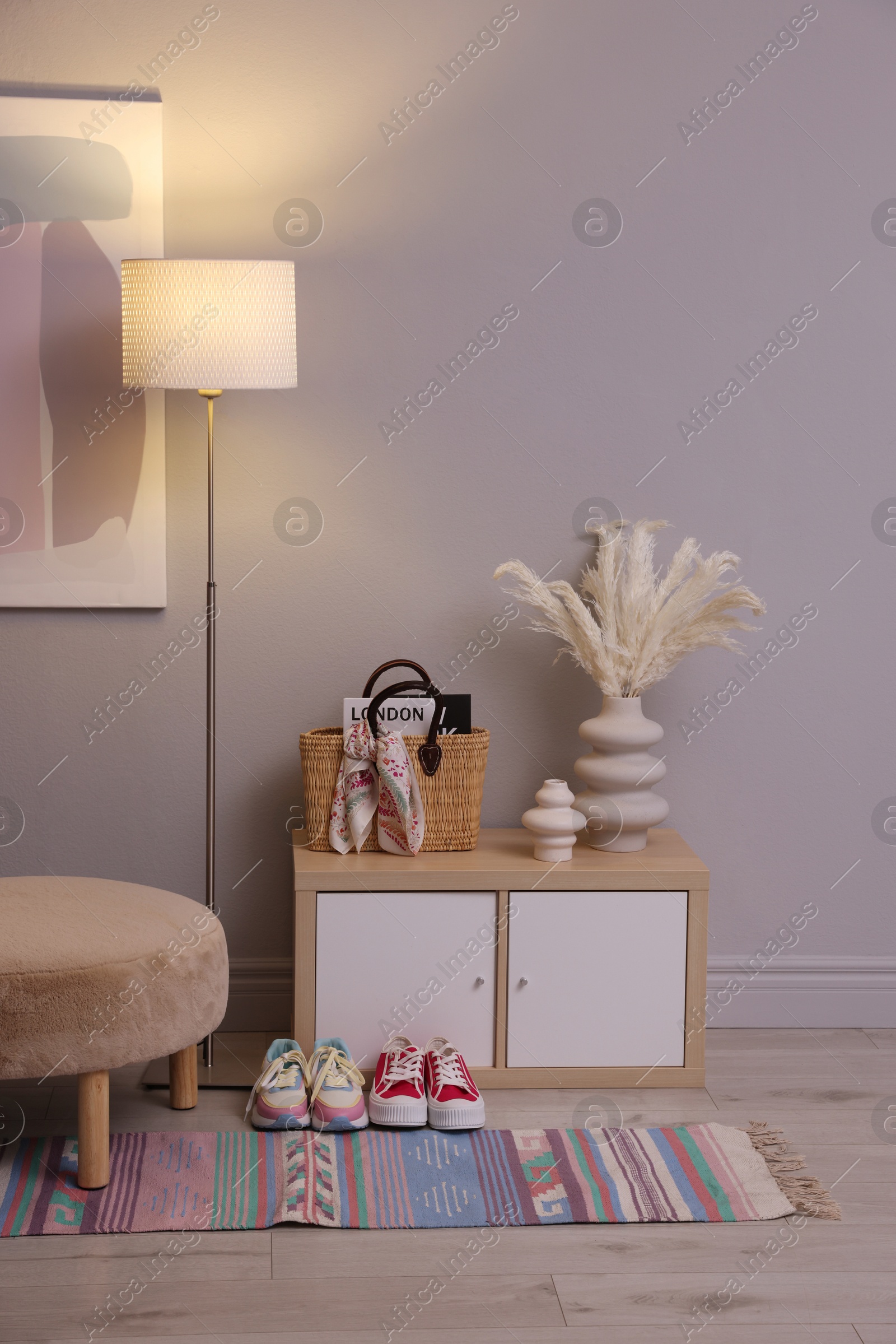 Photo of Stylish hallway interior with pouf and lamp