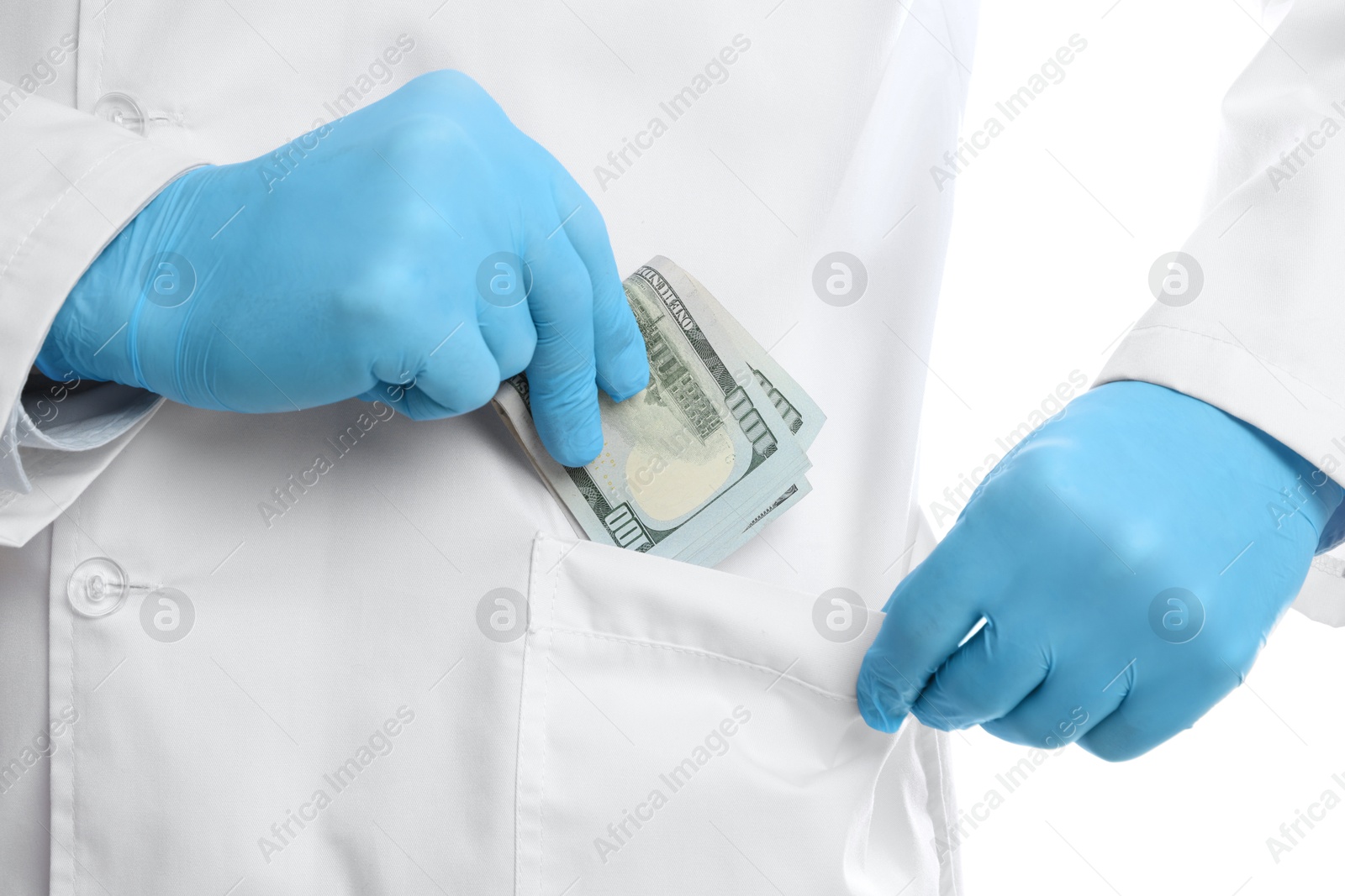 Photo of Corruption concept. Doctor putting dollar banknotes into his pocket on white background, closeup