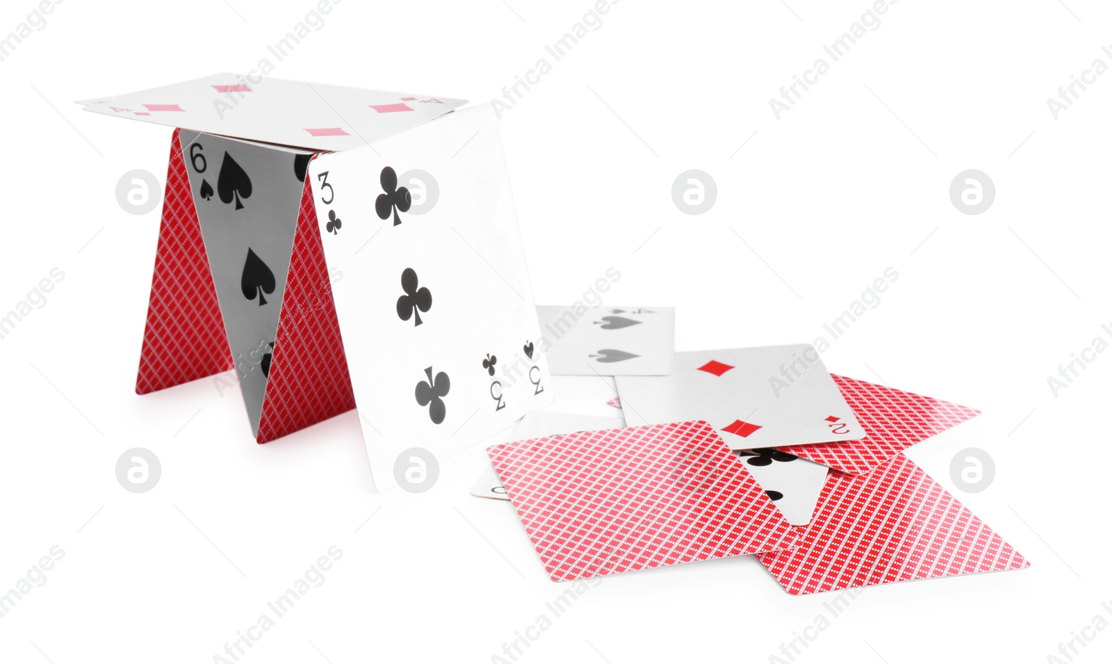 Photo of Collapsed house of playing cards isolated on white