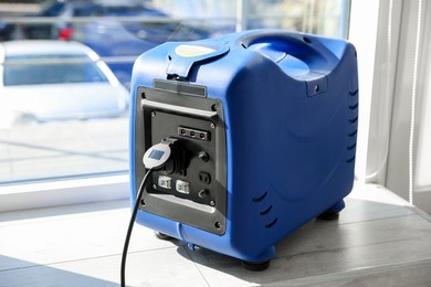 Photo of Modern portable power station near window indoors