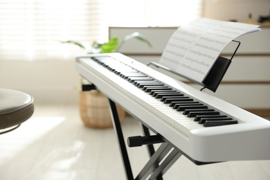 Photo of Synthesizer with music sheets and chair indoors