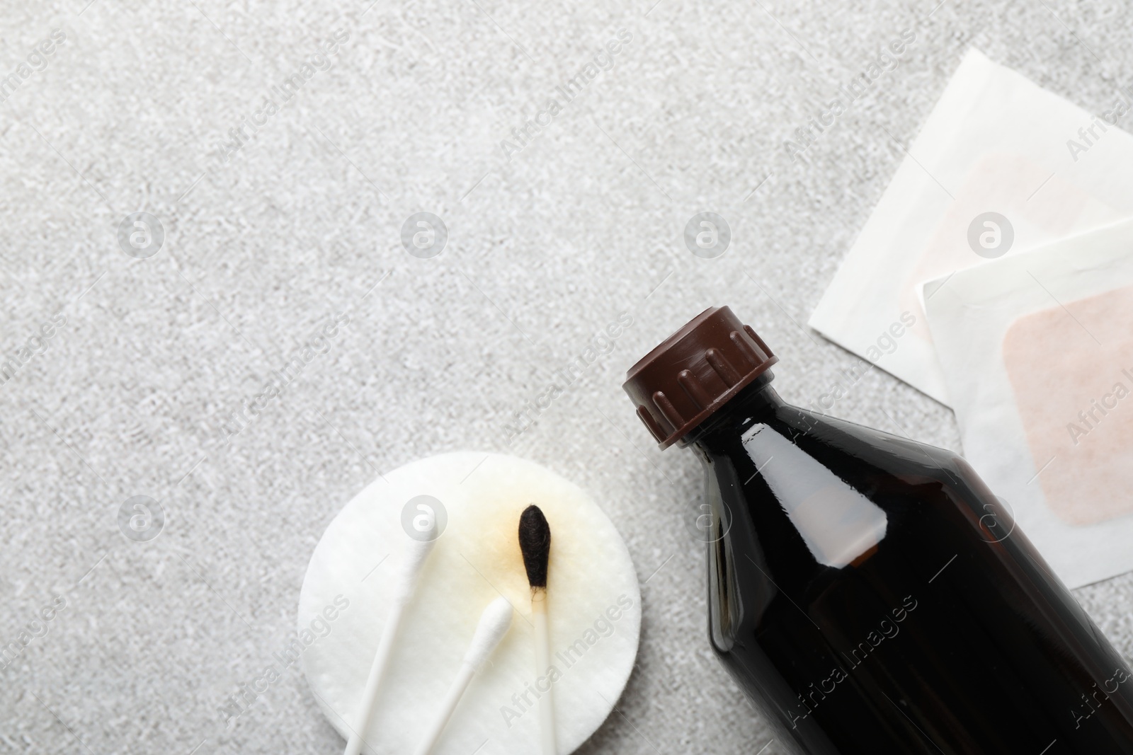 Photo of Topical iodine, cotton pad, swabs and adhesive bandages on light background, flat lay. Space for text