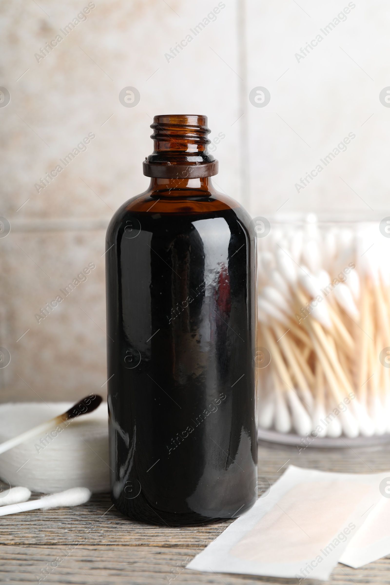 Photo of Topical iodine, cotton pads, swabs and adhesive bandages on wooden table