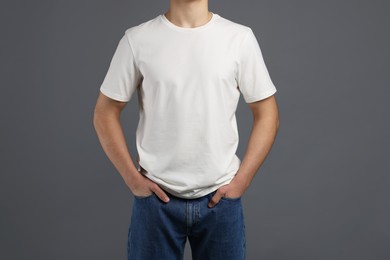 Photo of Man in stylish t-shirt on grey background, closeup. Mockup for design