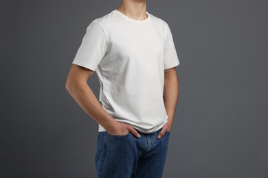 Photo of Man in stylish t-shirt on grey background, closeup. Mockup for design