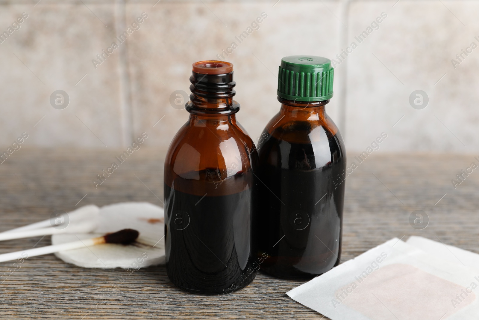 Photo of Topical iodine, cotton pad, swabs and adhesive bandages on wooden table