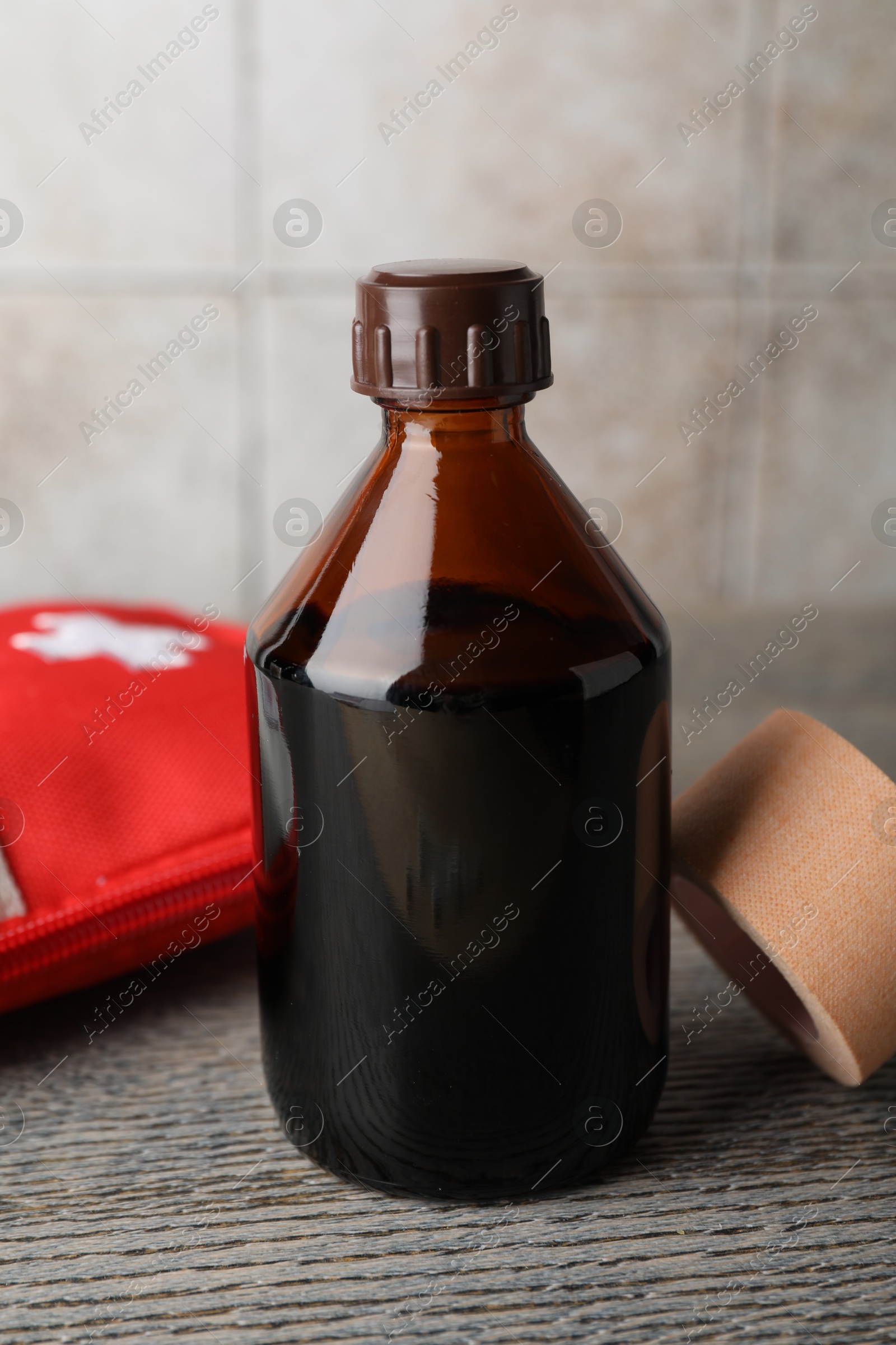 Photo of Topical iodine, adhesive bandage and first aid kit on wooden table