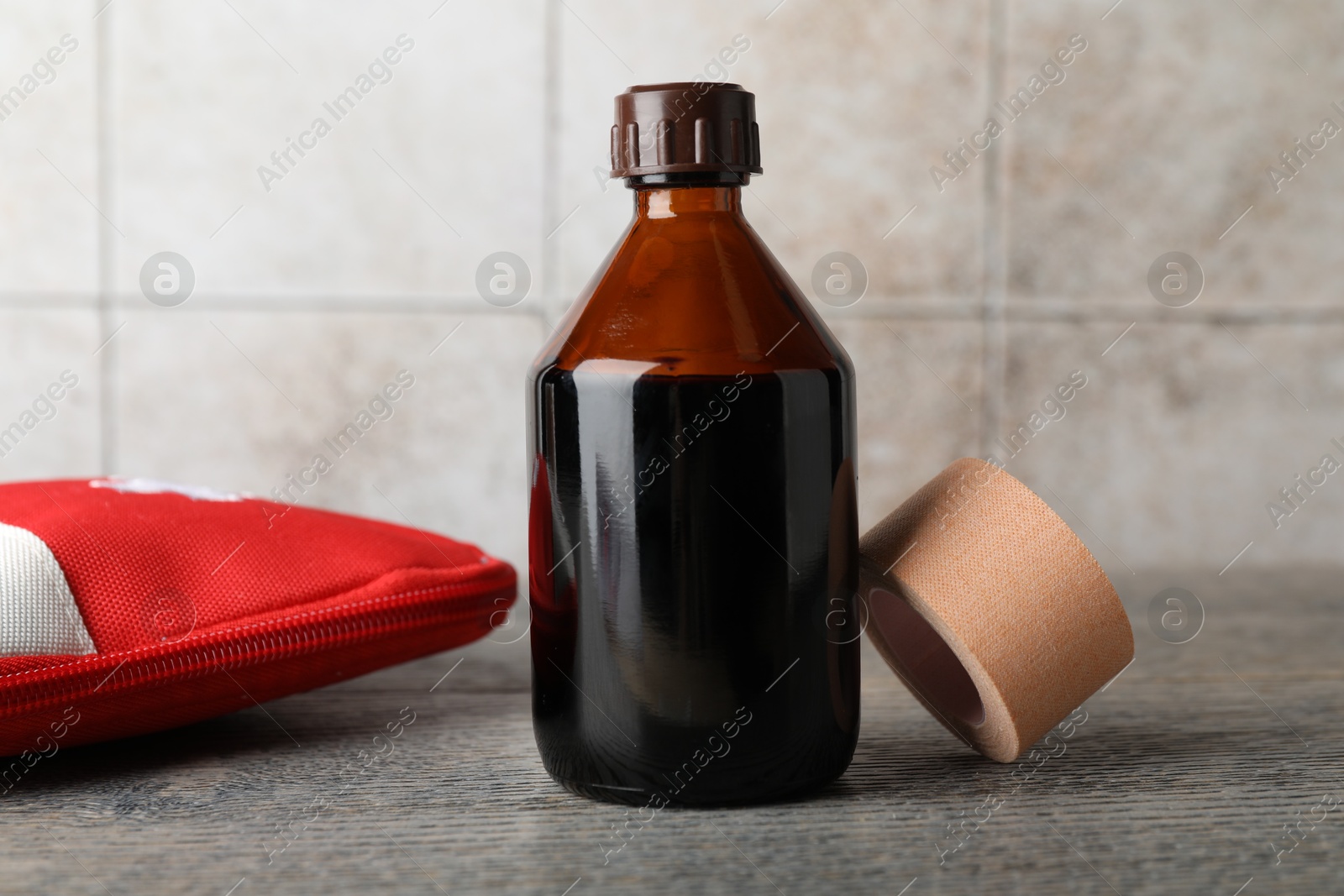 Photo of Topical iodine, adhesive bandage and first aid kit on wooden table