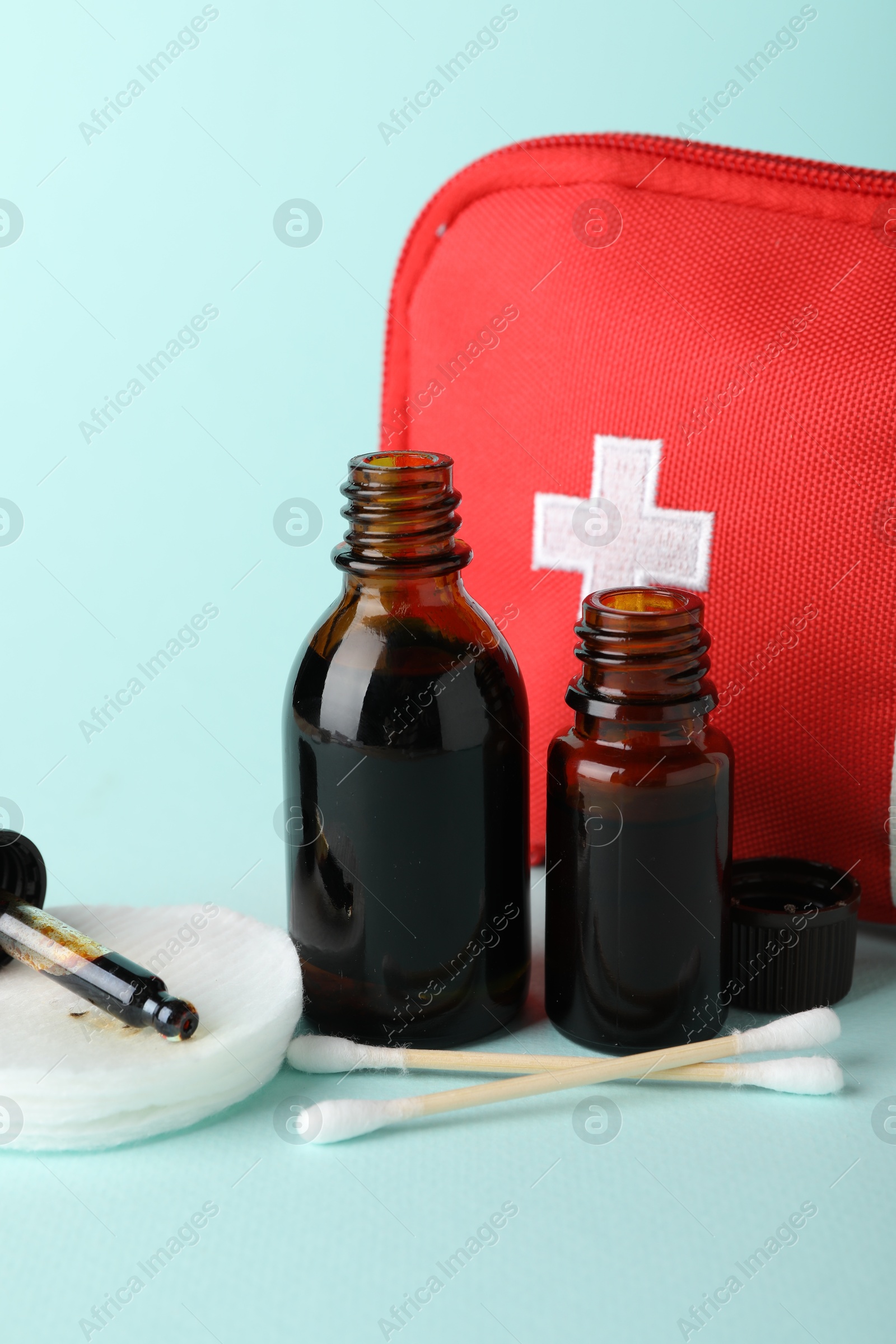 Photo of Topical iodine and other first aid kit components on light blue background