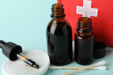 Photo of Topical iodine and other first aid kit components on light blue background