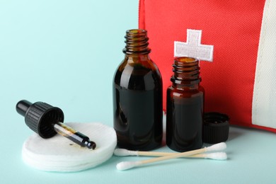 Photo of Topical iodine and other first aid kit components on light blue background