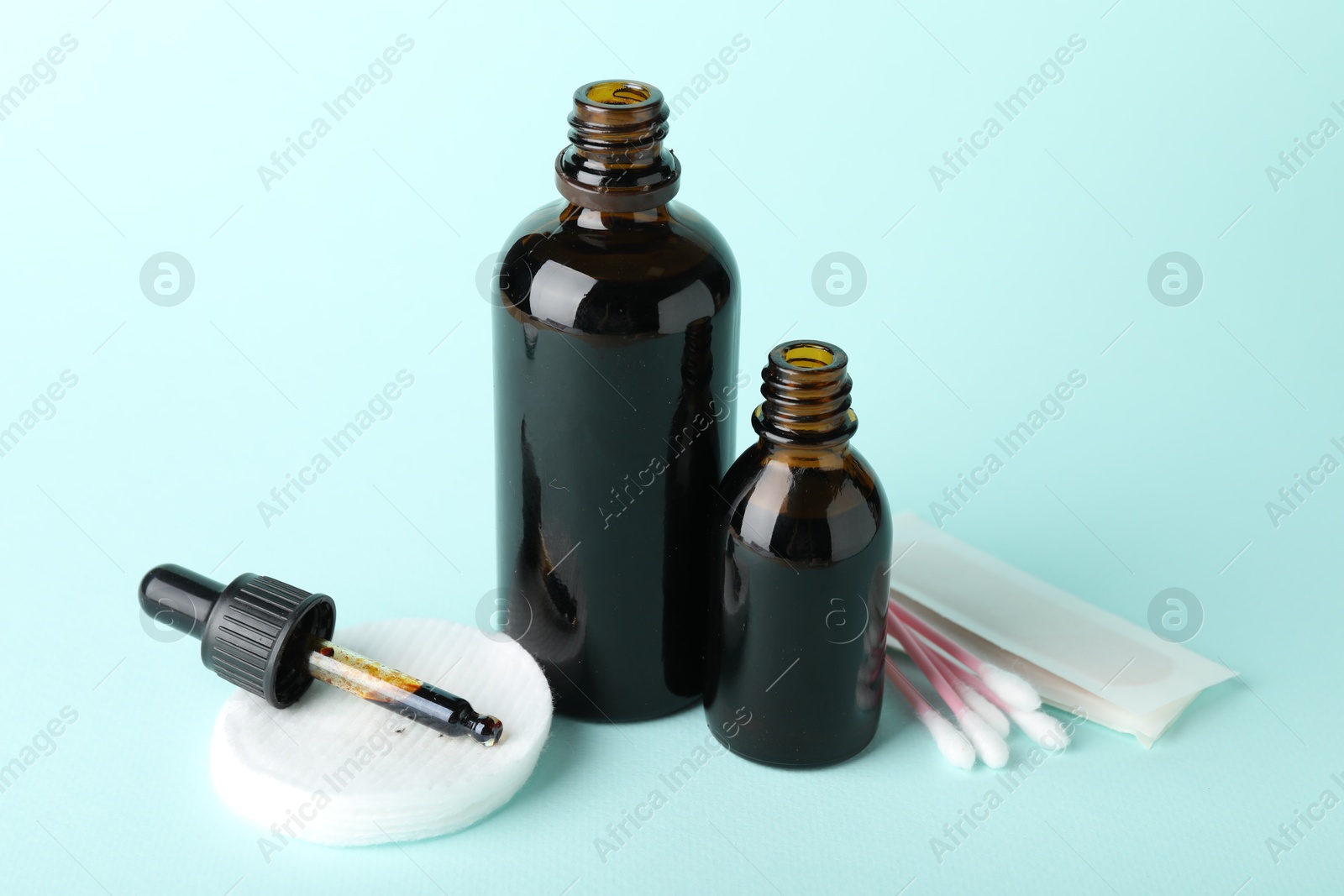 Photo of Topical iodine, cotton pads, swabs and adhesive bandage on light blue background