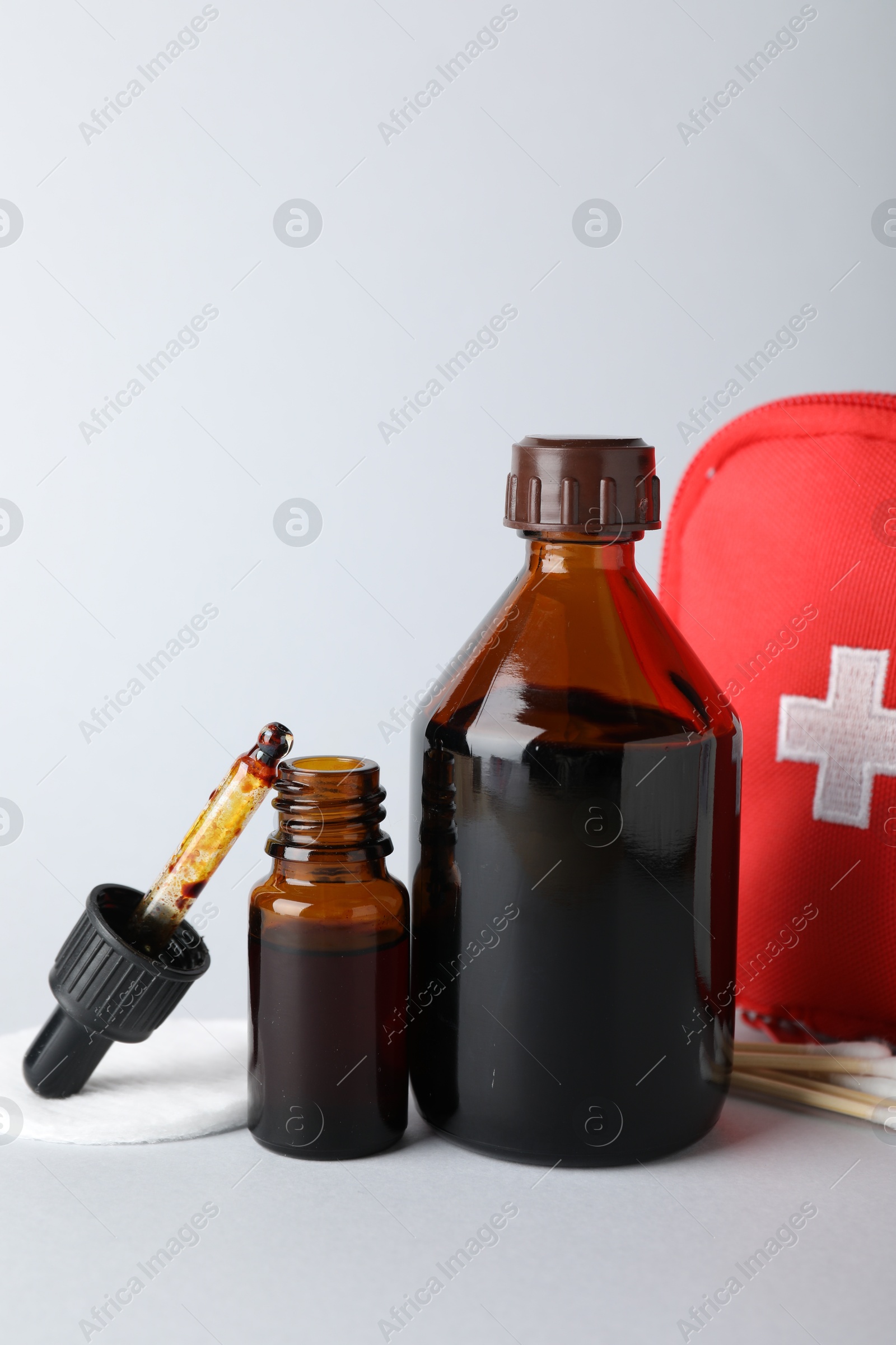 Photo of Topical iodine and other first aid kit components on light background